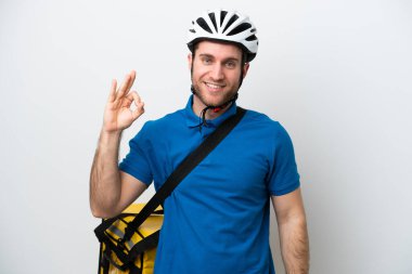 Beyaz arka planda izole edilmiş termal sırt çantalı beyaz adam parmaklarıyla tamam işareti gösteriyor.