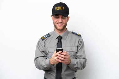 Beyaz arka planda izole edilmiş genç bir güvenlik görevlisi cep telefonuyla bir mesaj gönderiyor.