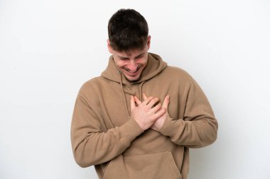 Beyaz arka planda soyutlanmış beyaz tenli yakışıklı bir adamın kalbi ağrıyor.