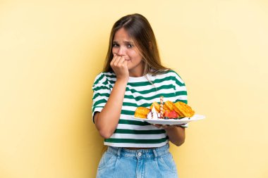 Sarı arka planda gözleme tutan Kafkasyalı genç bir kadın şüpheleri var.