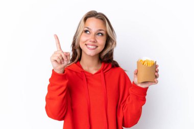 Beyaz arka planda izole edilmiş kızartma cipsleri tutan genç Rus kız harika bir fikre işaret ediyor.