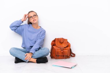 Beyaz arka planda izole bir katta oturan genç kız şüpheleri vardı ve kafası karışmıştı.