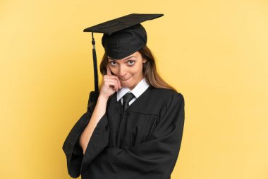 Genç üniversite mezunu sarı arka planda tek başına bir fikir düşünüyor.