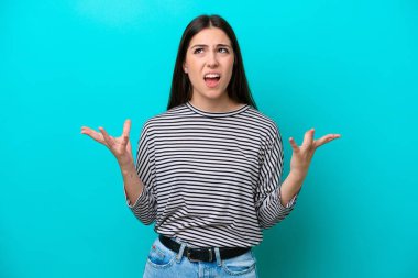 Mavi arka planda izole edilmiş genç beyaz kadın bunalımda.