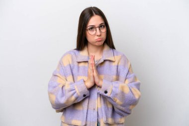 Young girl isolated on white background keeps palm together. Person asks for something