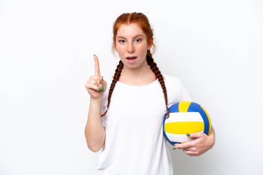 Beyaz arka planda voleybol oynayan beyaz tenli genç beyaz kadın çözümü fark ederken parmağını kaldırmayı amaçlıyor.