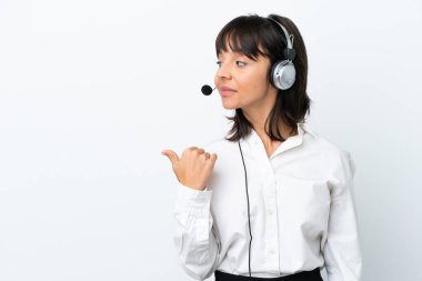 Tele pazarlamacı, beyaz arka planda izole edilmiş bir kulaklıkla çalışan melez bir kadın bir ürünü sunmak için kenarı işaret ediyor.