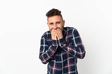 Beyaz arka planda izole edilmiş beyaz bir adam mutlu ve gülümseyen elleriyle ağzını kapatıyor.