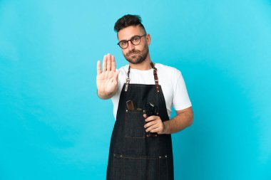 Önlüklü bir berber dur işareti yapıyor.