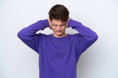 Beyaz arka planda izole edilmiş genç bir Rus adam hayal kırıklığına uğramış ve kulaklarını kapatmış.