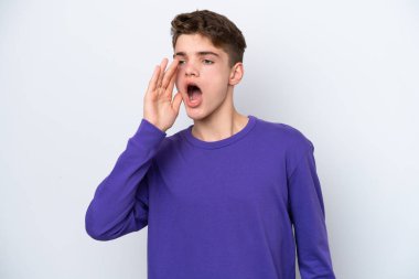 Beyaz arka planda izole edilmiş genç Rus adam ağzı sonuna kadar açık bağırıyor.