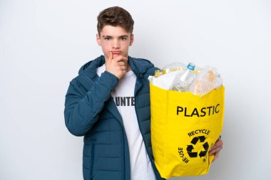 Beyaz arka planda geri dönüşüm yapmak için elinde plastik şişelerle dolu bir çanta tutan Rus bir gencin şüpheleri ve düşünceleri vardı.