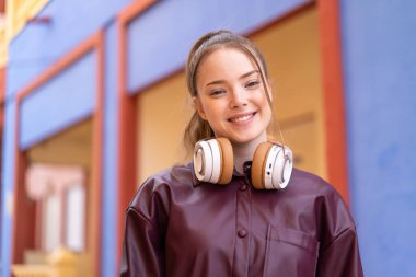 Genç ve güzel bir kız açık havada Neşeli bir ifadeyle