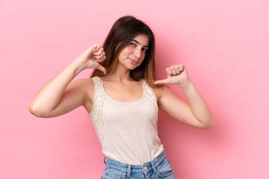 Genç beyaz kadın pembe arka planda soyutlanmış gururlu ve kendini beğenmiş.