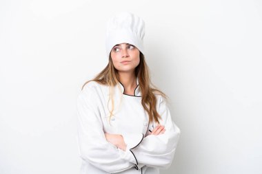 Beyaz arka planda izole edilmiş beyaz tenli bir kadın omuzlarını kaldırırken şüpheyle hareket ediyor.