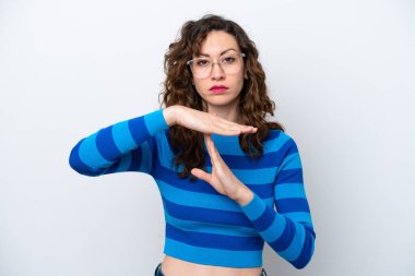 Beyaz arka planda izole edilmiş genç beyaz bir kadın zaman aşımı hareketi yapıyor.