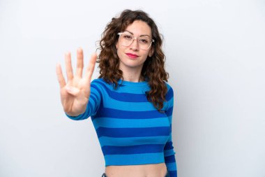 Beyaz arka planda izole edilmiş genç beyaz kadın mutlu ve parmaklarıyla dörde kadar sayıyor.