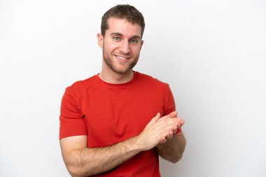 Beyaz arka planda izole edilmiş genç beyaz adam alkışlıyor.