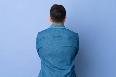 İzole edilmiş mavi arka planda beyaz adam var.