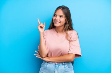 Mavi arka planda izole edilmiş beyaz bir kadın harika bir fikre işaret ediyor.