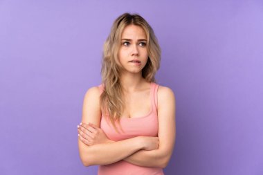 Genç Rus kız, mor arka planda izole edilmiş ve kafası karışmış bir yüz ifadesi var.