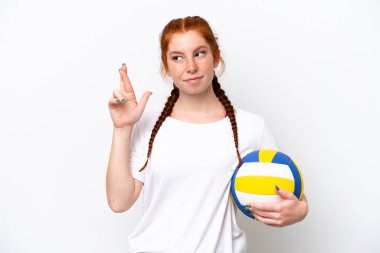 Beyaz arka planda izole bir şekilde voleybol oynayan beyaz tenli genç bir kadın.