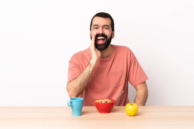 Beyaz bir adam kahvaltısını yapıyor ve ağzı açık bağırıyor..