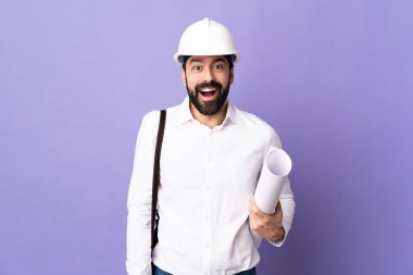Miğferli genç bir mimar. Mor arkaplanının planlarını tutuyor.