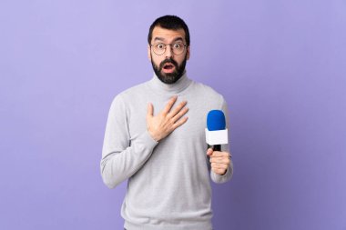 Mor arka planda sakallı yetişkin bir muhabir, sağa bakarken şaşırmış ve şok olmuştu.