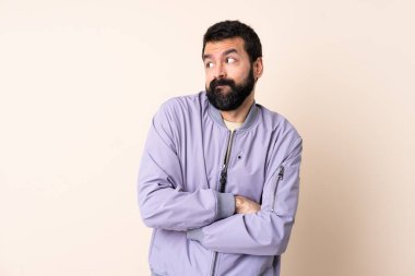 İzole edilmiş arka plan üzerinde ceket giyen beyaz bir adam omuzlarını kaldırırken şüpheyle hareket ediyor.