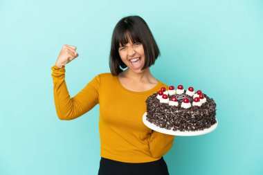 Genç melez kadın doğum günü pastasını tutarak zaferi kutluyor.
