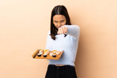 Genç, esmer, melez bir kadın. Sushi 'yi izole edilmiş arka planda tutuyor.