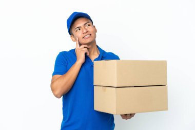 Delivery Ecuadorian man isolated on white background thinking an idea while looking up