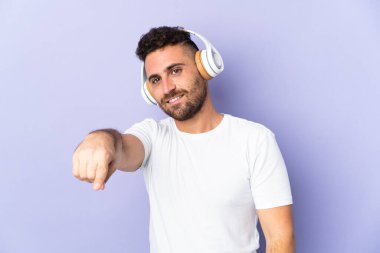 Mor arka planda izole edilmiş beyaz adam müzik dinliyor.