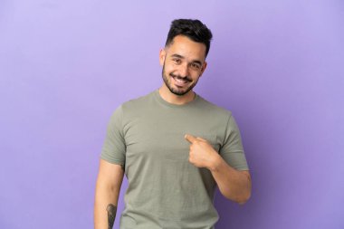 Mor arka planda yüzü sürpriz bir ifadeyle izole edilmiş genç beyaz bir adam.