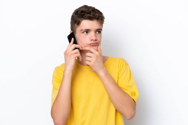 Beyaz arka planda izole edilmiş cep telefonu kullanan genç adamın şüpheleri var