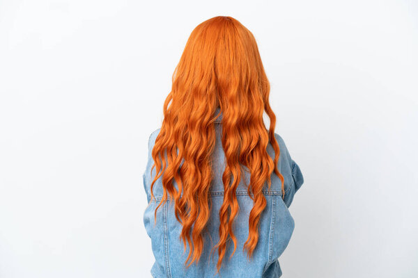 Молодая женщина с оранжевыми волосами изолированы на белом фоне в задней позиции
