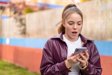 açık havada Smartphone kullanan güzel genç kadın         