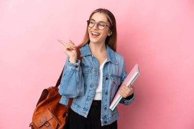 Pembe arka planda izole edilmiş genç beyaz kadın parmak kaldırarak çözümü bulmaya çalışıyordu.