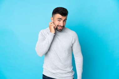 İzole edilmiş mavi arka planı olan beyaz bir adam gülüyor.