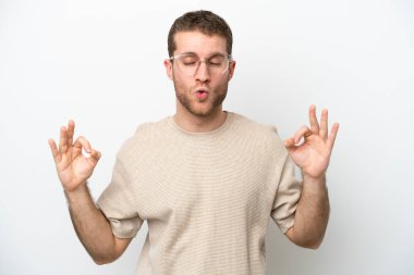 Beyaz arka planda Zen pozisyonunda beyaz tenli genç bir adam