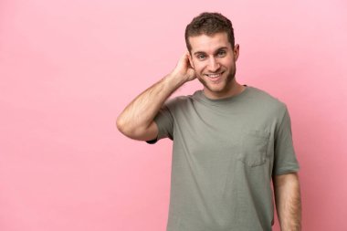 Pembe arka planda izole edilmiş genç beyaz adam gülüyor.