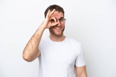 Beyaz arka planda izole edilmiş beyaz tenli genç bir adam mutlu bir ifadeyle gözlüklü.