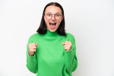 Beyaz arka planda izole edilmiş genç beyaz kadın galibiyeti kutluyor.