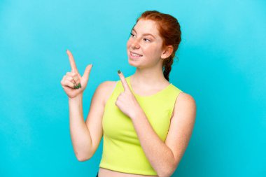 Mavi arka planda izole edilmiş genç bir kadın işaret parmağıyla işaret etmek harika bir fikir.