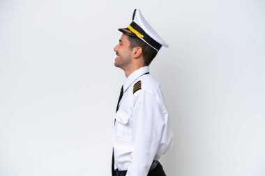 Airplane pilot over isolated white background laughing in lateral position