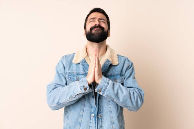 Tecrit edilmiş geçmişi olan beyaz sakallı bir adam avuç içlerini bir arada tutar. İnsan bir şey ister.