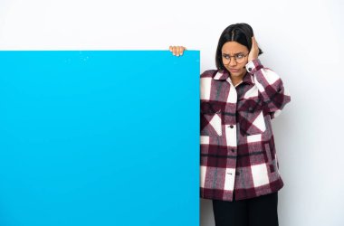 Beyaz arka planda izole edilmiş büyük mavi pankartlı melez bir kadın hayal kırıklığına uğramış ve kulaklarını kapatmış.