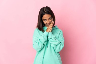 Pembe arka planda izole edilmiş genç Latin kadın avuç içlerini bir arada tutuyor. İnsan bir şey ister.