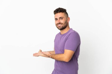 Beyaz arka planda izole edilmiş beyaz bir adam, davet edilmek için ellerini yana uzatıyor.